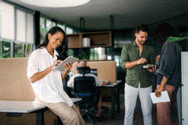 Çeşitli, yetenekli bir takım, bir iş toplantısı sırasında parlak bir ofis alanında etkili bir şekilde işbirliği yapar. Birlikte çalışan başarılı iş arkadaşlarından oluşan yaratıcı bir grup