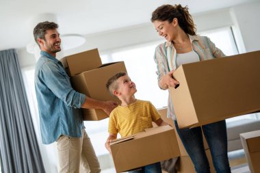 Yeni ev, kutu ve çocuklu aileler, yeni ev kredisi ve gayrimenkul yatırımları. Ev sahibi, taşınma günü için heyecanlı aile, taşınma ve kiralama konsepti