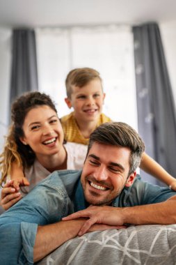 Üç kişilik bir aile evde neşeyle vakit geçirir. Çocukların iyi ruh hali ailelere zevk verir..