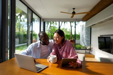 Dijital yaşam tarzı ve çevrimiçi bağlantı. Modern teknoloji odaklı dünyada eğlence, alışveriş ve kusursuz iletişimin tadını çıkaran çok ırklı mutlu bir çift.