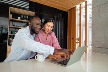 İş ekibi, iki mutlu çeşitlilik, çok ırklı yönetici ofiste dizüstü bilgisayar kullanarak birlikte çalışıyorlar. Genç iş kadını yöneticisi iş toplantısında sunum yapıyor, danışmanlık yapıyor.