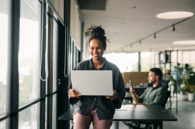 Mixed team of software engineers brainstorming ideas for new code library in front of computer screens compiling algorithms. Diverse app developers collaborating on group project in it agency office.