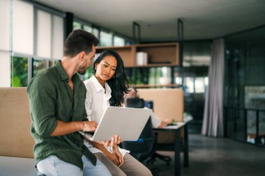 İş projesi ekibi şirket ofisindeki toplantı odasında birlikte çalışıyor.
