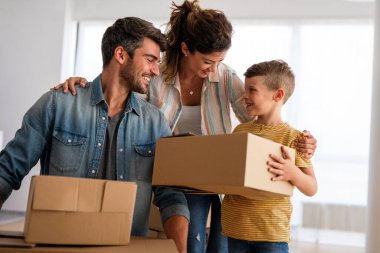 Yeni ev, kutu ve çocuklu aileler, yeni ev kredisi ve gayrimenkul yatırımları. Ev sahibi, taşınma günü için heyecanlı aile, taşınma ve kiralama konsepti