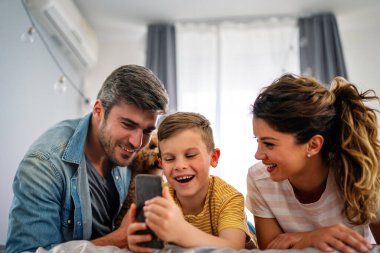 Mutlu teknoloji bağımlısı aile babası ve çocuk evde dizüstü bilgisayar dijital tableti kullanıyor, sosyal medyayı aşırı kullanan cihazlara takıntılı çocuk, internet bağımlılığı kavramı