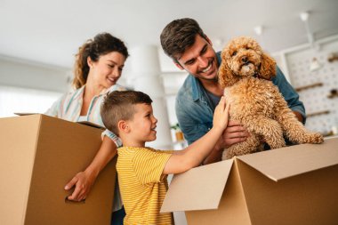 Yeni bir apartmanda kutularla taşınan çocuklu mutlu bir aile. Ev sahibi, taşınma günü için heyecanlı aile, taşınma ve kiralama konsepti