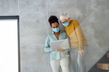 Meşgul iş adamları, programcılar yazılım geliştirici mühendisi ofiste bilgisayar üzerinde çalışıyor. Kadın çoklu etnik programcı koruyucu yüz maskeleri konusunda uzman.