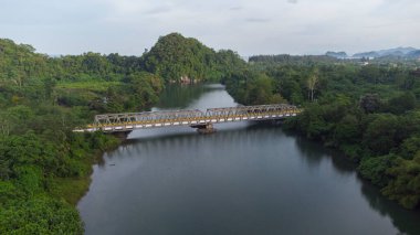 Beautiful natural scenery of tropical forest river with green hills and trees in the background.
