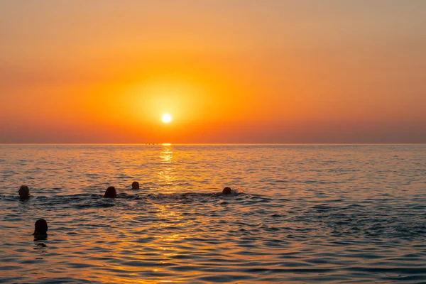 stock image Batumi, Georgia - 30 August, 2022: Beautiful sunset on the black sea, Black Sea with swimmers on foreground