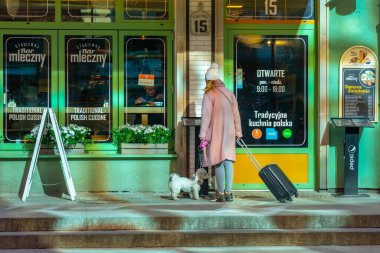 Gdansk, Polonya - 11 Mart 2022: Gdansk 'ta bir barın girişinde küçük bir köpeği olan turist. Seyahat