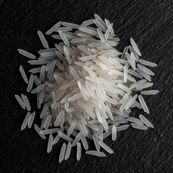 White rice on a black graphite stone slab, healthy food