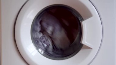 Evde çamaşır makinesinde çamaşır yıkamak. dönen davul çamaşır makinesi