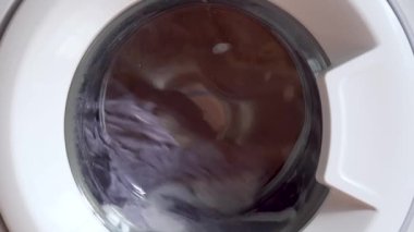 Evde çamaşır makinesinde çamaşır yıkamak. dönen davul çamaşır makinesi