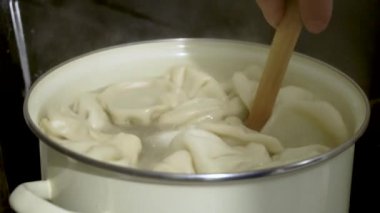 Ev mutfağında kaynayan su dolu tencerede el yapımı khinkali. Geleneksel Gürcü Yemekleri