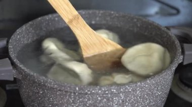 Ev mutfağında kaynayan su dolu tencerede el yapımı khinkali. Geleneksel Gürcü Yemekleri
