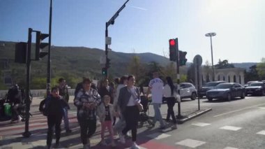 Tiflis, Gürcistan - 13 Nisan 2024: Yayalar Tiflis 'teki Vake Park' a doğru bir trafik ışığından karşıya geçtiler