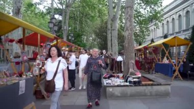 Tiflis, Gürcistan - 20 Nisan 2024: Rustaveli Bulvarı 'ndaki sokak pazarındaki insanlar. Seyahat