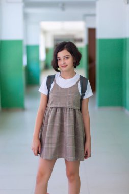 Okul koridorundaki güzel kız kameraya poz veriyor, eğitim görüyor.