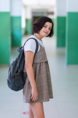 Okul koridorundaki güzel kız kameraya poz veriyor, eğitim görüyor.