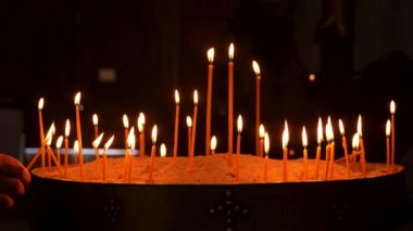 Yakıcı mumlara yakın çekim, birden fazla mum parıl parıl yanıyor. Yavaş çekim