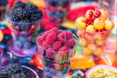 Taze olgun böğürtlen, çilek, böğürtlen ve böğürtlen karışımı sokak pazarında plastik kutularda