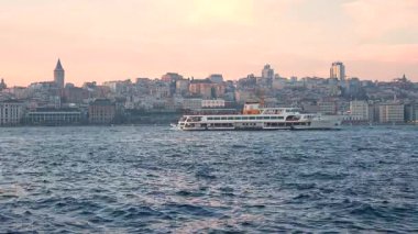 İstanbul, Türkiye - 7 Mart 2025: Arkasında Galata Kulesi olan yelkenli gemilerle Golden Horn Körfezi manzarası. İstanbul 'da gün batımı
