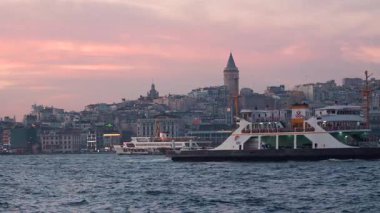 İstanbul, Türkiye - 7 Mart 2025: Arkasında Galata Kulesi olan yelkenli gemilerle Golden Horn Körfezi manzarası. İstanbul 'da gün batımı