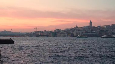 İstanbul, Türkiye - 7 Mart 2025: Arkasında Galata Kulesi olan yelkenli gemilerle Golden Horn Körfezi manzarası. İstanbul 'da gün batımı