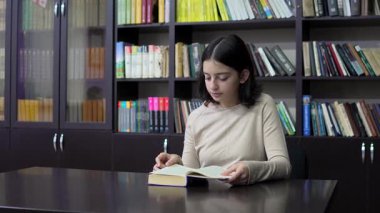 Kütüphanede kitap okuyan ergen kız. Eğitim. Yavaş çekim
