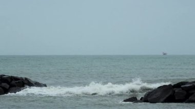 Dalgalar deniz kıyısındaki kayalara çarpıyor, deniz manzarası, Fiumichino plajı. Yavaş çekim