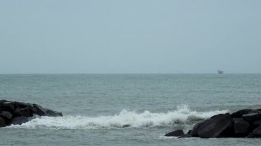 Dalgalar deniz kıyısındaki kayalara çarpıyor, deniz manzarası, Fiumichino plajı. Yavaş çekim
