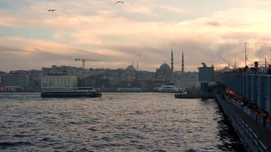 İstanbul, Türkiye - 7 Mart 2025: Galata Köprüsü 'nde altın boynuzda balık avı, arka planda Galata Kulesi. Seyahat