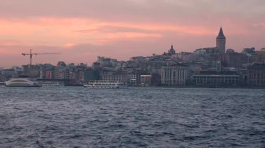 İstanbul, Türkiye - 7 Mart 2025: Arkasında Galata Kulesi olan yelkenli gemilerle Golden Horn Körfezi manzarası. İstanbul 'da gün batımı
