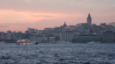 İstanbul, Türkiye - 7 Mart 2025: Arkasında Galata Kulesi olan yelkenli gemilerle Golden Horn Körfezi manzarası. İstanbul 'da gün batımı