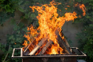 Ahşap ızgaraya kömür üretmek için metal ızgarada yanar. barbekü