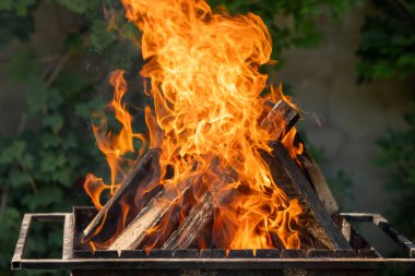 Ahşap ızgaraya kömür üretmek için metal ızgarada yanar. barbekü