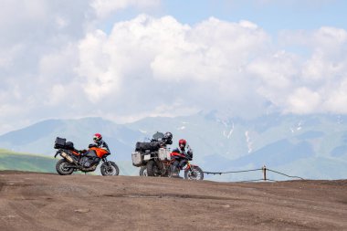 Gürcistan 'ın Khevsureti Dağları manzaralı yüksek bir dağ toprak yolunda iki tur motosikleti. Seyahat