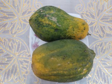 Masadaki beyaz tencerede olgun Papaya meyvesi