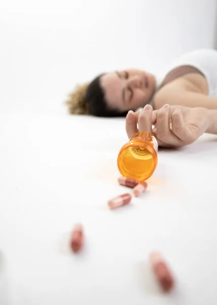 Stock image Scene of a girl lying on the floor with a pill overdose (intentional selective focus)