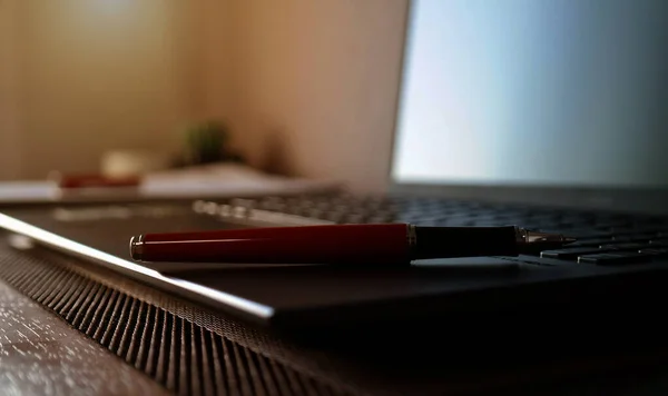Długopis Zamazanym Laptopie Materiały Biurowe Stole Biurze — Zdjęcie stockowe