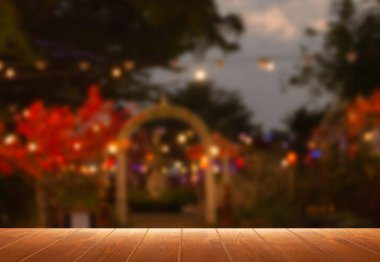 perspective wooden board over blurred garden of restaurant at night