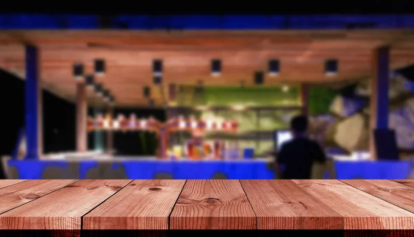 perspective wooden board bar over blurred beverage counter bar in restaurant at night