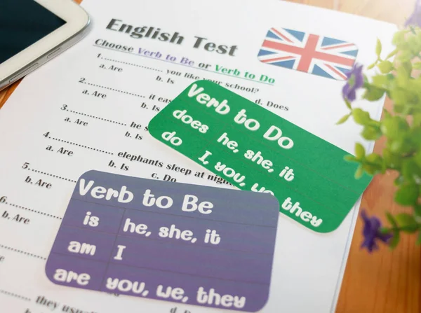 English grammar test on wooden table in classroom