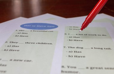 Sınıftaki masada renkli İngilizce dil bilgisi sınav kağıdı