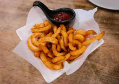 Taze altın kıvırcık patates kızartması ve ketçap. 