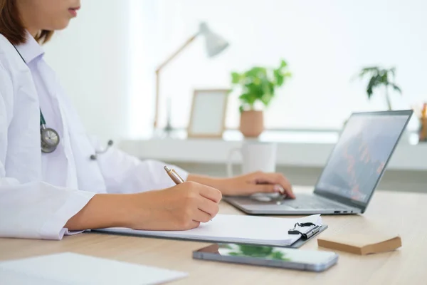 Beyaz Üniformalı Bir Doktorun Laptopunu Kullanıp Klinikte Tıbbi Tavsiyelerde Bulunurken — Stok fotoğraf