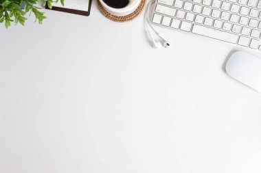 Klavyeli beyaz ofis masası, saksı, kahve fincanı ve defter. Metnin için boşluk kopyala.