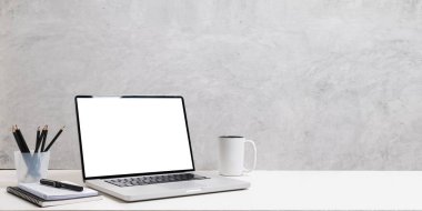 Dizüstü bilgisayar, kalem tutacağı, kahve fincanı ve defterleri beyaz masaya koyun. Alan kopyala, reklam tasarımın için boş ekran.