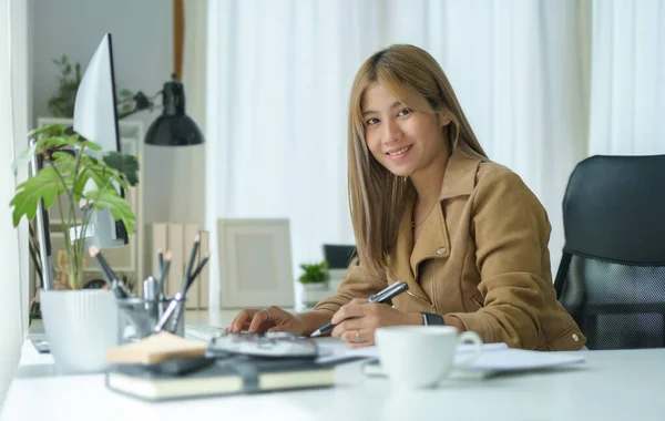 stock image Confident millennial female entrepreneur sitting in her personal office and smiling to camera.	