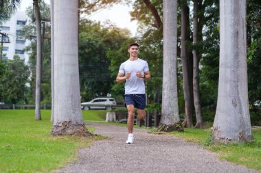 Güneşin doğuşunda parkta koşan sporcu bir adam. Sağlıklı, sağlıklı, sağlıklı yaşam tarzı..